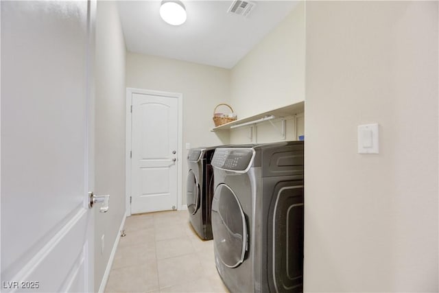 laundry area with light tile patterned floors and washer and dryer