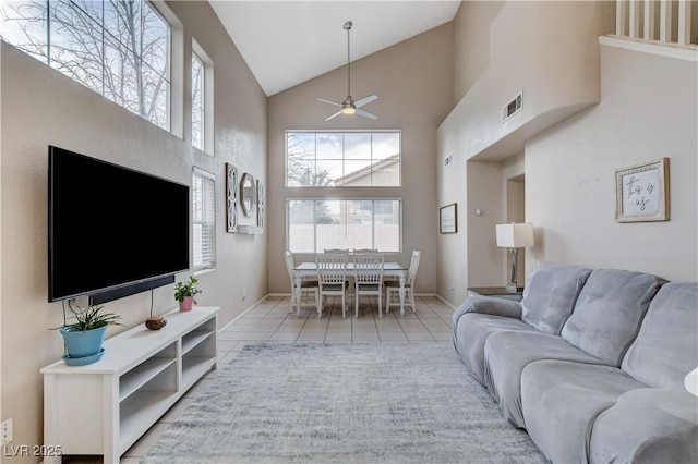 tiled living room with high vaulted ceiling and ceiling fan