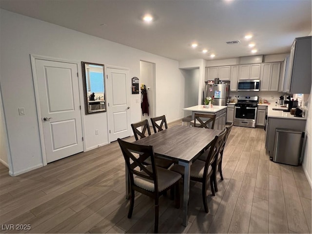 dining space featuring wood-type flooring and sink