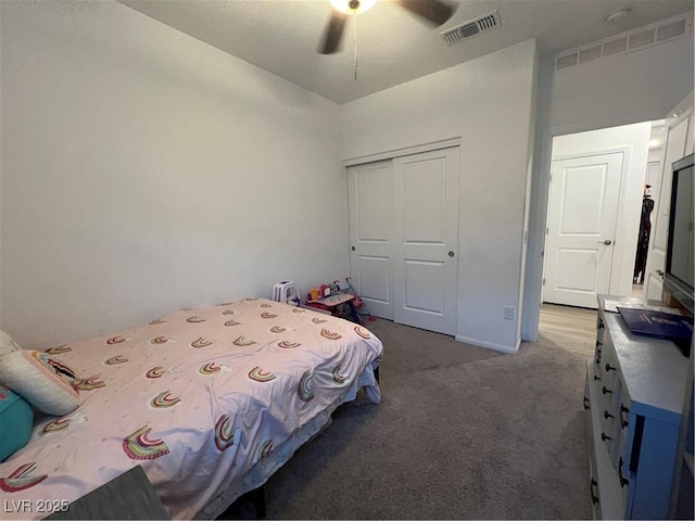 bedroom with ceiling fan, dark carpet, and a closet