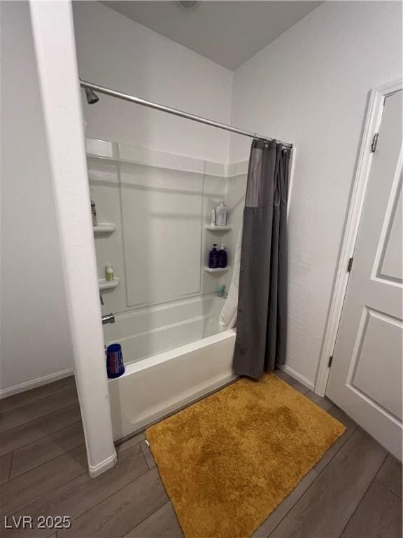 bathroom with wood-type flooring and shower / bathtub combination with curtain