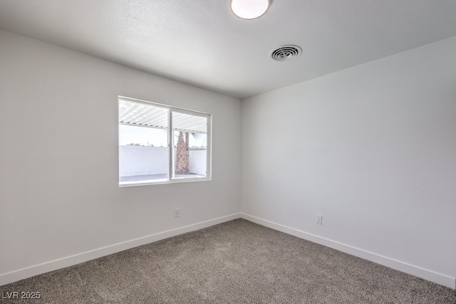 carpeted spare room with visible vents and baseboards