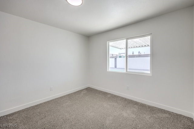 carpeted spare room featuring baseboards