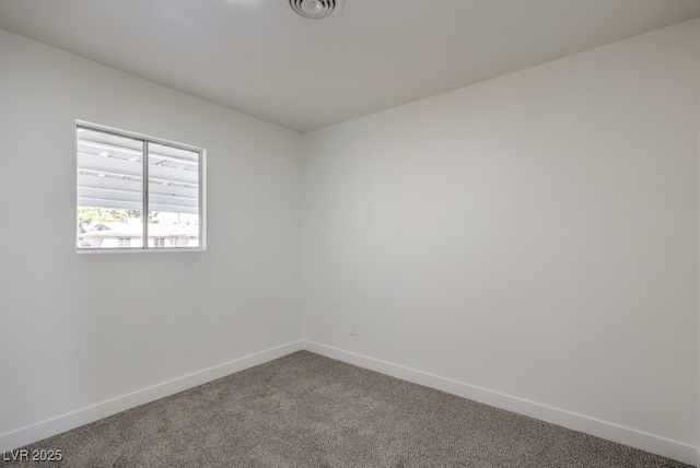 carpeted empty room featuring baseboards