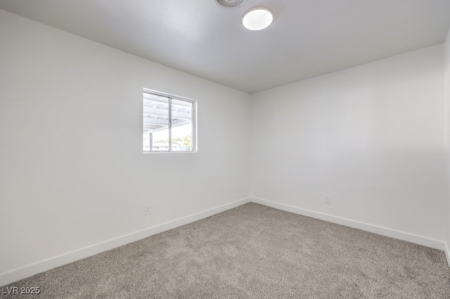 carpeted empty room featuring baseboards