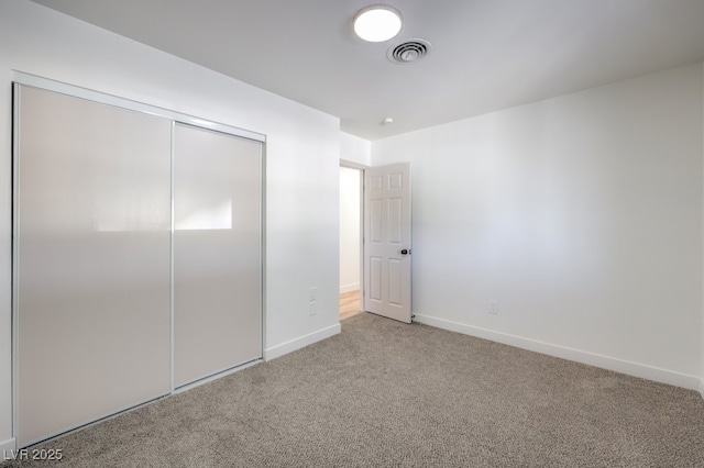 unfurnished bedroom featuring carpet floors and a closet