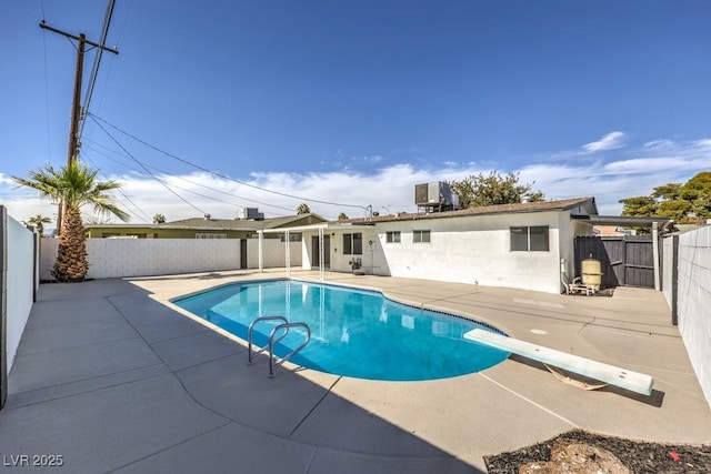 view of pool with a patio, central AC unit, and a diving board