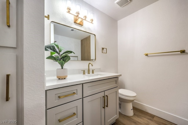 bathroom featuring vanity, hardwood / wood-style floors, and toilet