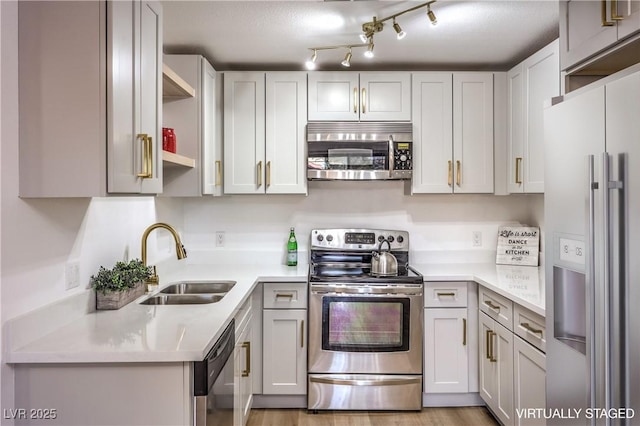 kitchen featuring stainless steel appliances, white cabinetry, and sink