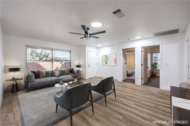 living room with ceiling fan and light hardwood / wood-style flooring