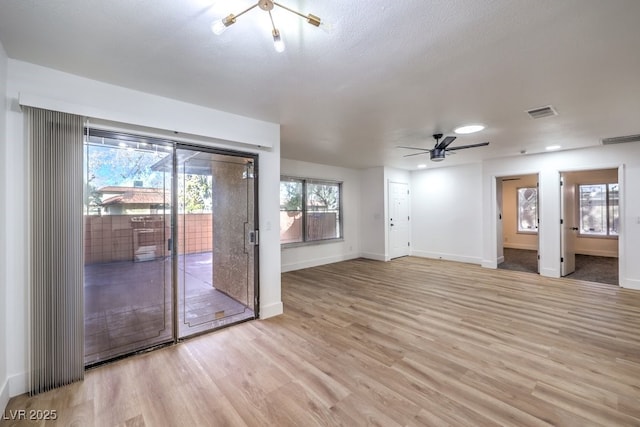 unfurnished living room featuring a textured ceiling, ceiling fan, and light hardwood / wood-style flooring