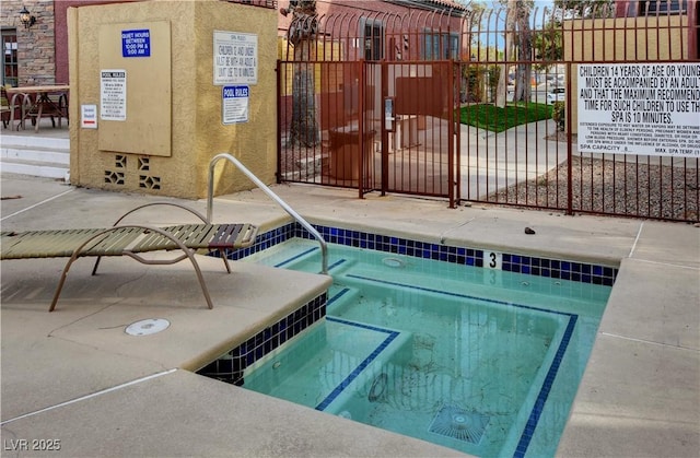 view of swimming pool with a hot tub