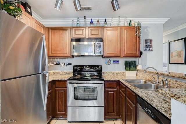 kitchen featuring sink, light tile patterned floors, ornamental molding, stainless steel appliances, and light stone countertops