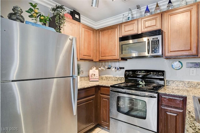 kitchen featuring light stone countertops, ornamental molding, and appliances with stainless steel finishes