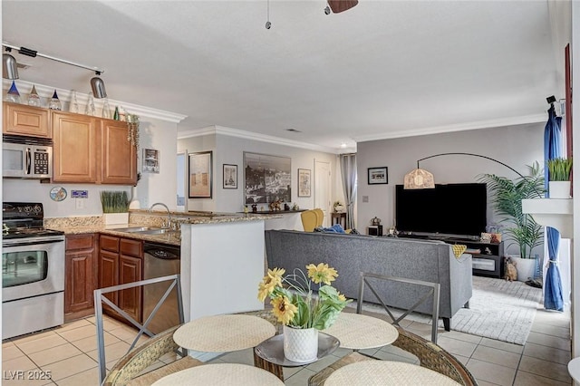 kitchen featuring sink, light tile patterned floors, ornamental molding, appliances with stainless steel finishes, and light stone countertops