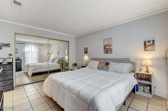 bedroom with ornamental molding, tile patterned floors, and a closet