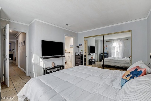 tiled bedroom featuring ornamental molding and a closet