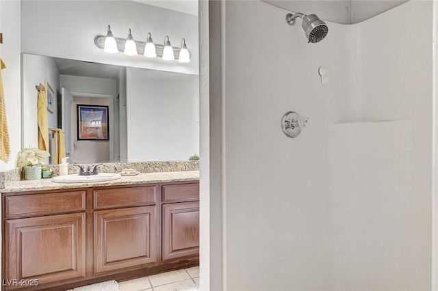 bathroom with tile patterned flooring, vanity, and walk in shower