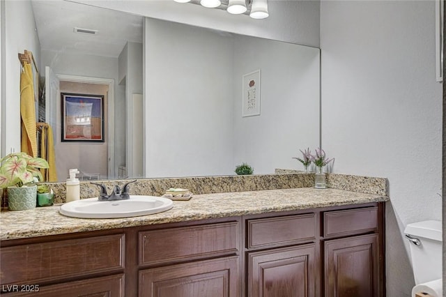 bathroom featuring vanity and toilet