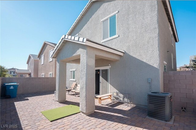 rear view of property with a patio area and central air condition unit