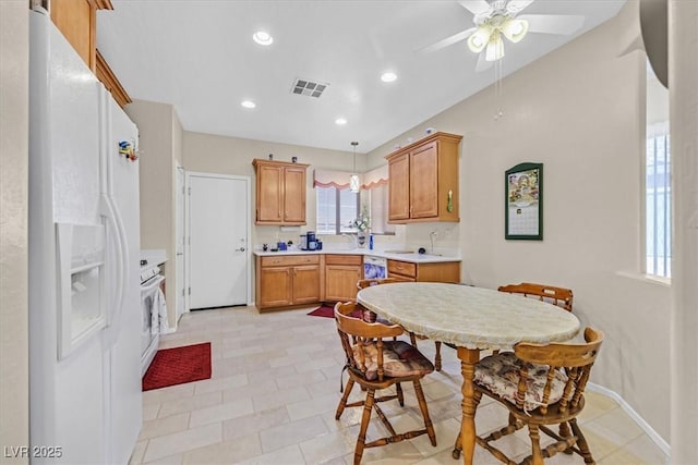 kitchen featuring stove, decorative light fixtures, white fridge with ice dispenser, and ceiling fan