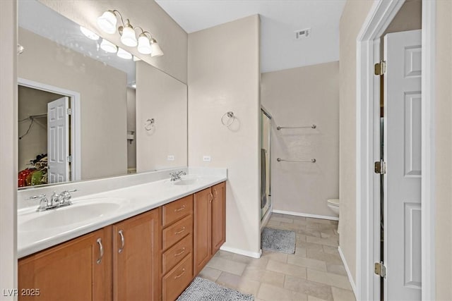 bathroom featuring tile patterned flooring, vanity, toilet, and a shower with shower door