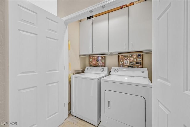 laundry room with washing machine and dryer and cabinets