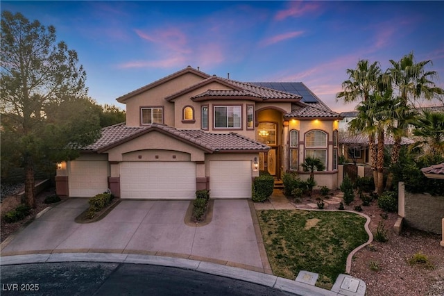 mediterranean / spanish-style home featuring a garage and solar panels