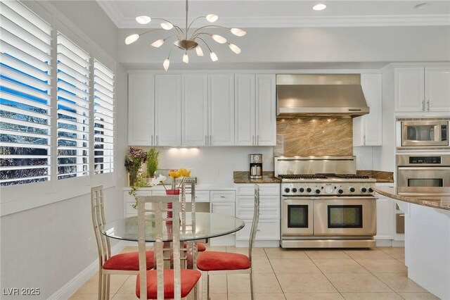 kitchen with stone counters, white cabinets, wall chimney exhaust hood, and appliances with stainless steel finishes