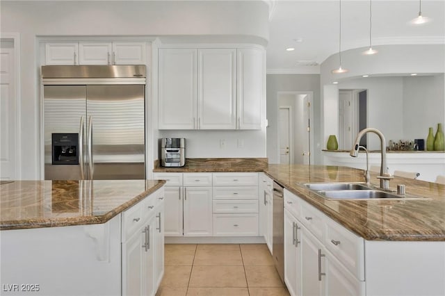 kitchen featuring pendant lighting, sink, appliances with stainless steel finishes, a kitchen island with sink, and white cabinets