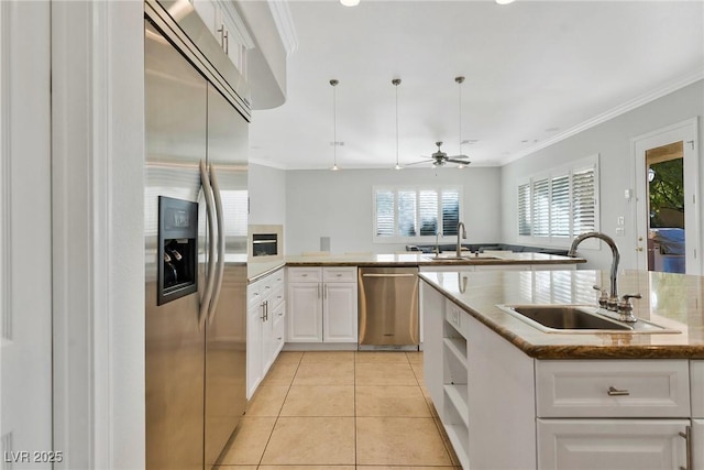 kitchen featuring light tile patterned flooring, appliances with stainless steel finishes, sink, and white cabinets