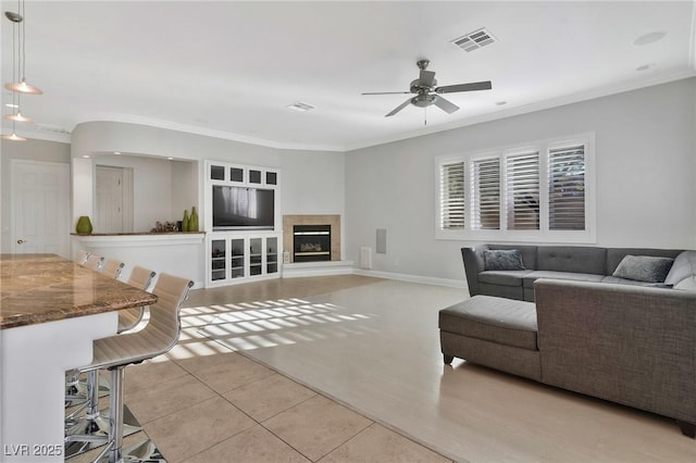 tiled living room featuring crown molding and ceiling fan