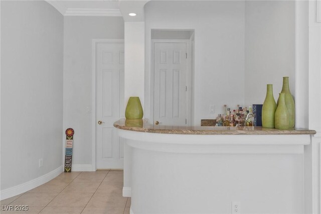 bar featuring ornamental molding and light tile patterned floors