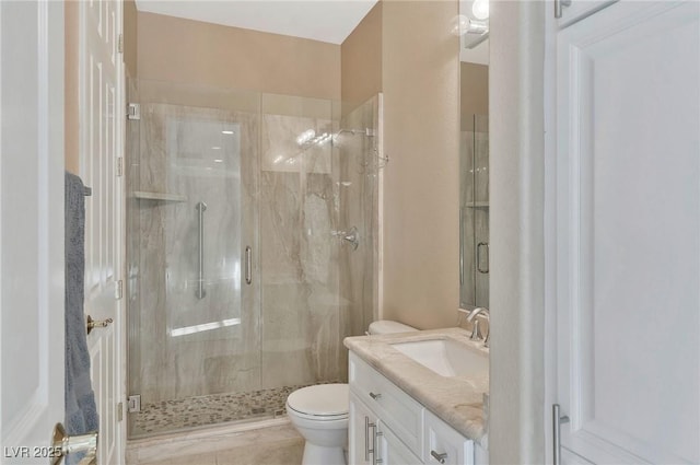 bathroom with a shower with door, vanity, and toilet