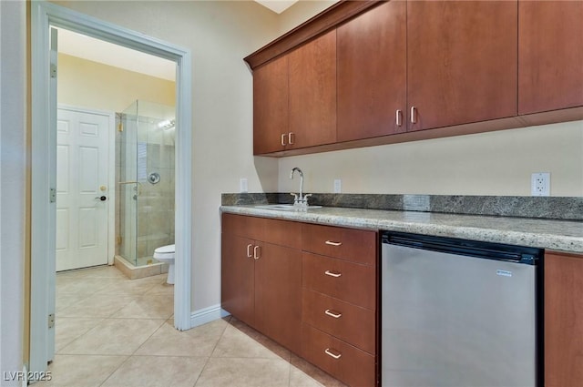 kitchen featuring sink, light tile patterned floors, stainless steel refrigerator, and dishwasher