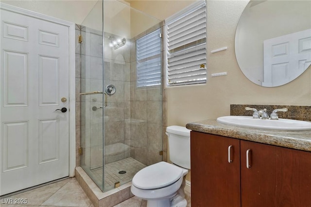 bathroom with tile patterned flooring, vanity, toilet, and a shower with shower door