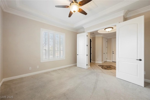 unfurnished bedroom featuring light carpet, crown molding, a raised ceiling, and ceiling fan