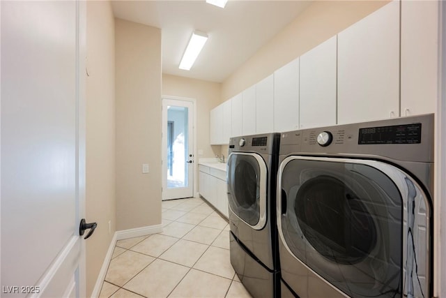 clothes washing area featuring cabinets, light tile patterned flooring, and separate washer and dryer