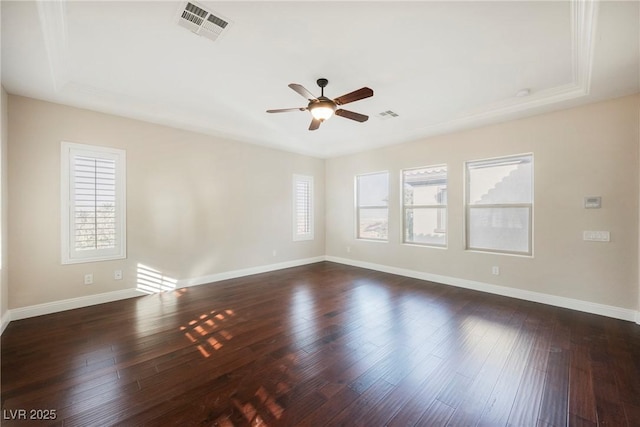 empty room featuring a wealth of natural light, dark hardwood / wood-style floors, and ceiling fan