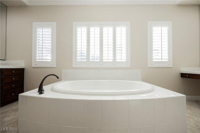 bathroom featuring vanity, tiled tub, and tile patterned floors