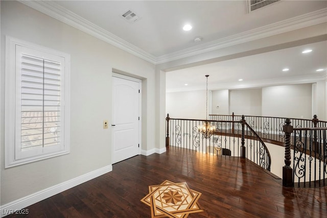 hallway featuring crown molding, dark hardwood / wood-style floors, and an inviting chandelier