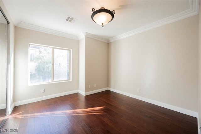 empty room featuring crown molding and dark wood-type flooring