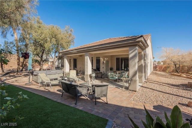 rear view of house with a hot tub and a patio