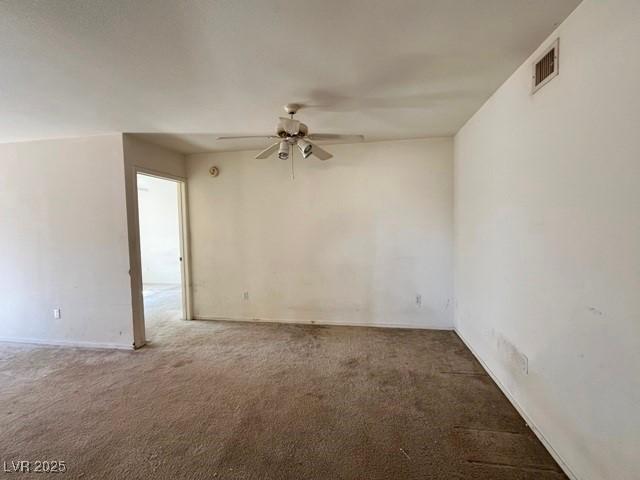 spare room featuring visible vents, carpet, and a ceiling fan