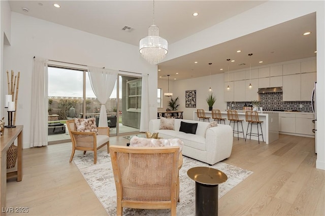 living room featuring an inviting chandelier and light hardwood / wood-style flooring