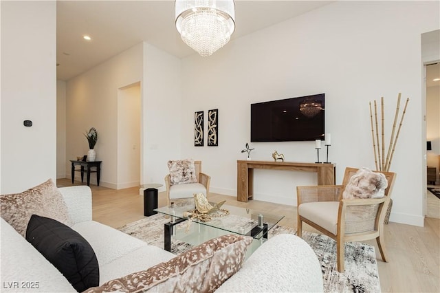 living room with an inviting chandelier and light wood-type flooring