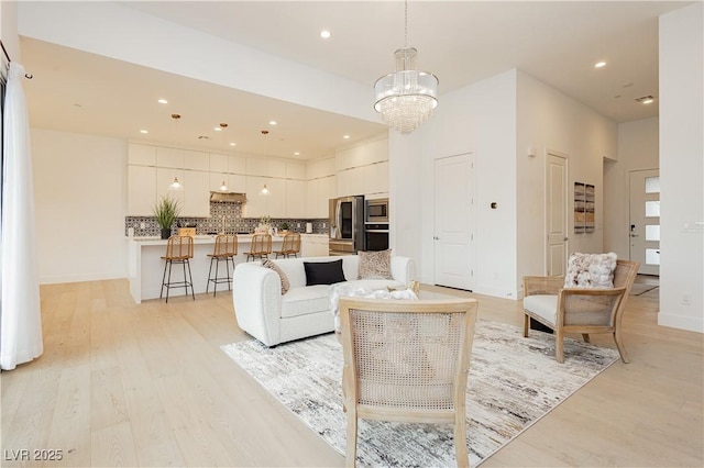 living room featuring light hardwood / wood-style flooring and a notable chandelier