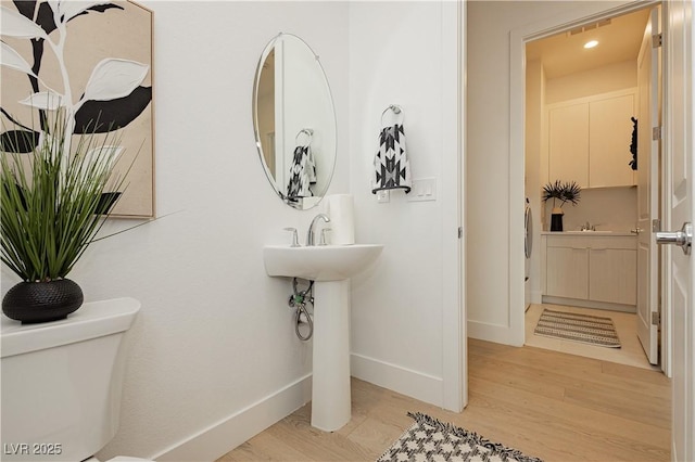 bathroom featuring hardwood / wood-style flooring, sink, and toilet