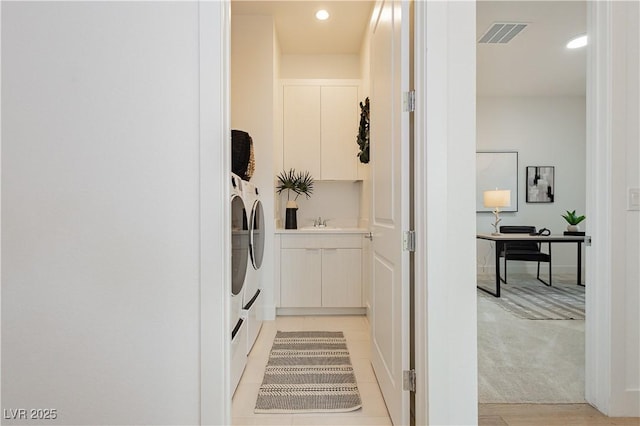 laundry room with light carpet, sink, cabinets, and washing machine and clothes dryer