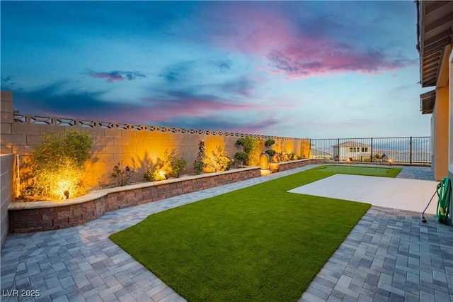 yard at dusk featuring a patio